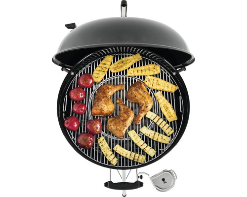 Kugelgrill mit Grillgut, bestehend aus Hähnchen, Zucchetti und Kartoffeln.