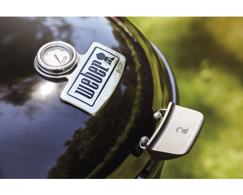 Detailansicht eines Kugelgrills mit Weber Logo, Temperaturanzeige und Deckelgriff