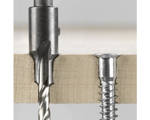 Foret Forstner en cours d''utilisation à côté d''une vis fraisée dans du bois