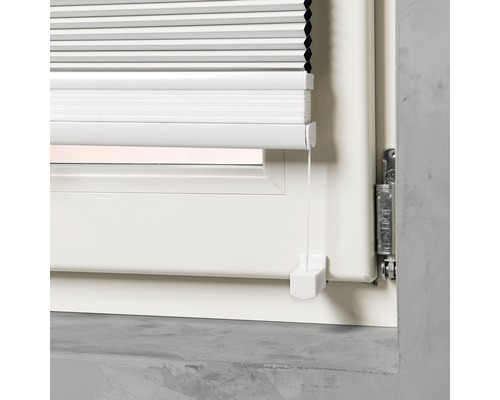 Vue détaillée d''un store plissé blanc sur une fenêtre