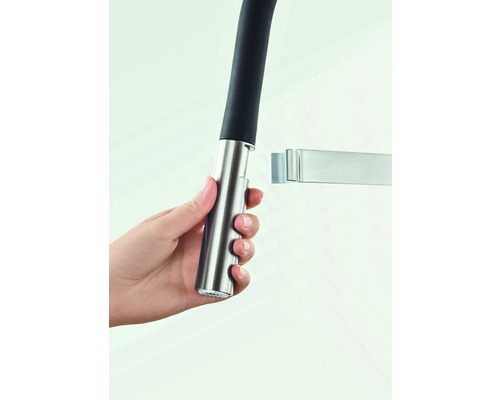 Main tenant un robinet de cuisine avec douchette extractible