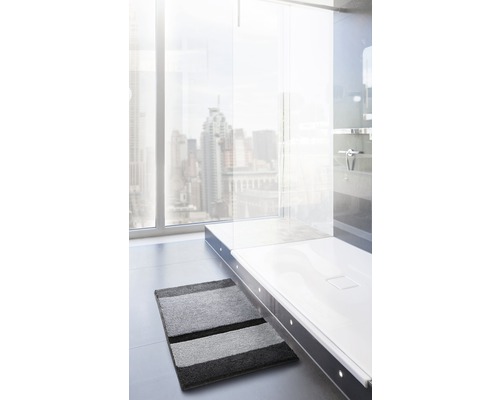 Salle de bains moderne avec cabine de douche, fenêtre et tapis de bain à rayures grises.