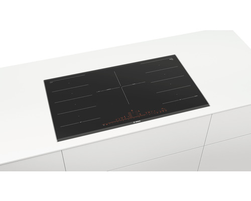 Table de cuisson à induction noire Bosch sur un plan de travail de cuisine