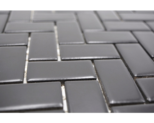 Gros plan d''une mosaïque de carreaux rectangulaires, disposés en chevrons.