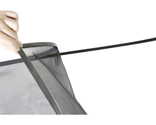 Nahaufnahme einer Person, die ein Fliegengitter mit Dichtung befestigt.