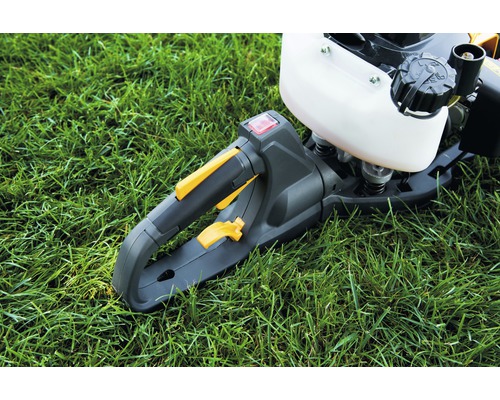 Gros plan sur la poignée d''un taille-haie sur du gazon.