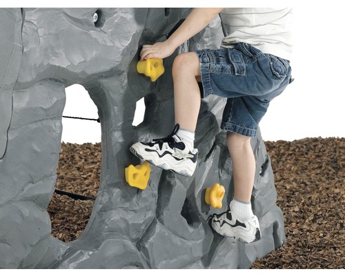 Un enfant escalade un mur d''escalade gris avec des prises jaunes