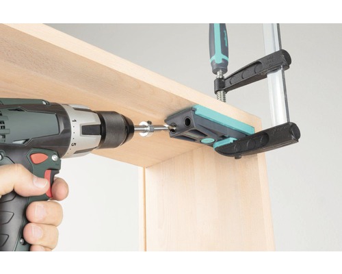 Akkuschrauber beim Bohren mit einer Bohrschablone in Holz