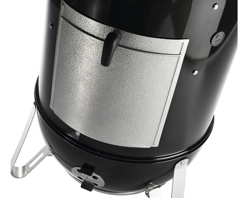 Detailansicht eines Kugelgrills mit einer Tür zum Nachlegen von Brennmaterial.