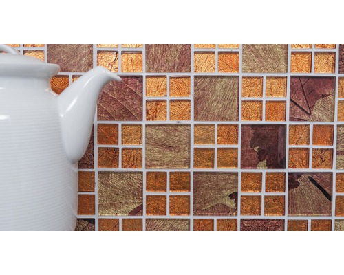 Gros plan d''une mosaïque avec des motifs de feuilles à côté d''une théière