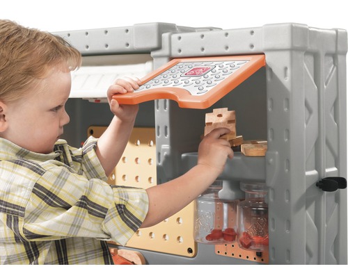 Enfant jouant avec un établi pour enfants avec des outils et des vis