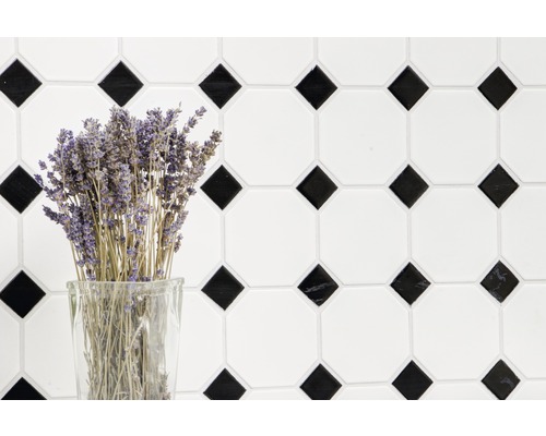Mur de carreaux décoratif avec motif géométrique et bouquet de lavande dans un verre.