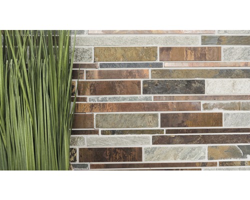 Mur de carreaux de mosaïque avec plante au premier plan