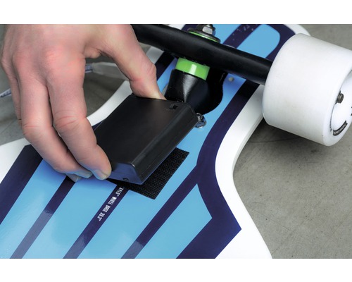 Befestigen einer schwarzen Batteriebox mit Klettverschluss auf einem Skateboard