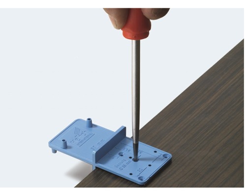 Outil pour percer avec précision des trous dans des panneaux de bois avec un tournevis.