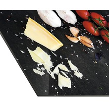 Dekoratives Küchenbrett mit Käse, Knoblauch und Tomaten