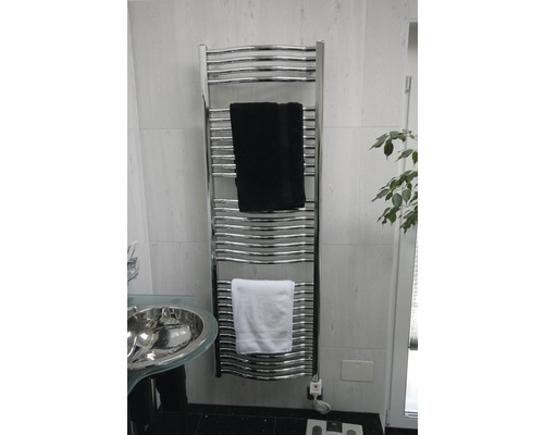 Sèche-serviettes chromé avec serviettes dans la salle de bain