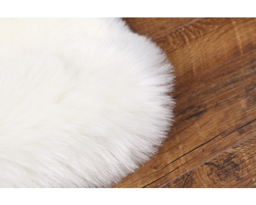 Tapis en fausse fourrure blanche sur parquet
