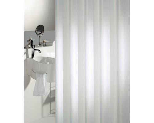 Salle de bain lumineuse avec rideau de douche, lavabo et accessoires