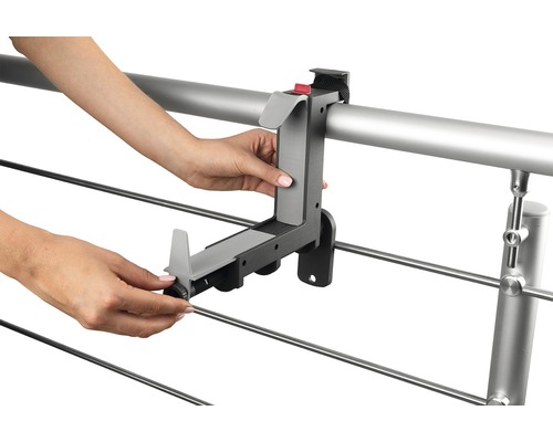 Person montiert einen Balkonkastenhalter an einem Geländer.