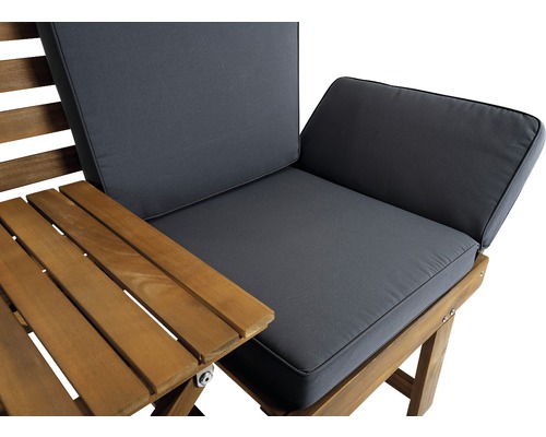 Detailansicht eines Gartenmöbels mit Holztisch und grauen Polstern