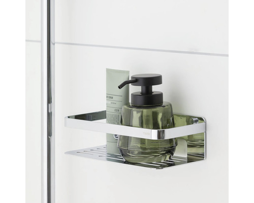 Étagère d''angle avec gel douche et distributeur de savon dans la salle de bain.