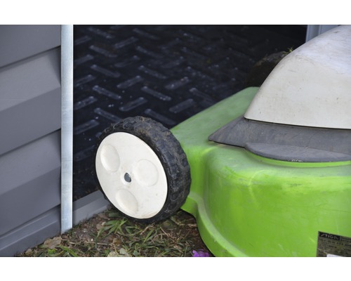 Vue détaillée d''une tondeuse à gazon devant une remise de jardin