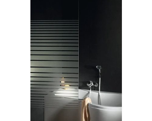 Badezimmer mit Badewanne, Duscharmatur und Duschwand mit Streifenmuster