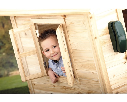 Junge schaut aus Fenster eines Holzspielhauses