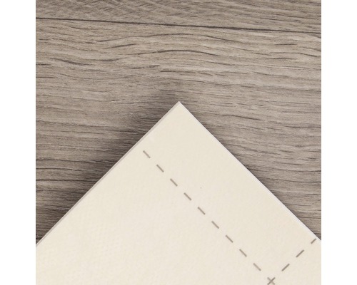 Gros plan d''un carreau de vinyle blanc avec des lignes pointillées sur un plancher en bois