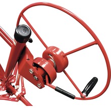 Vue détaillée d''un treuil à matériaux rouge avec manivelle.