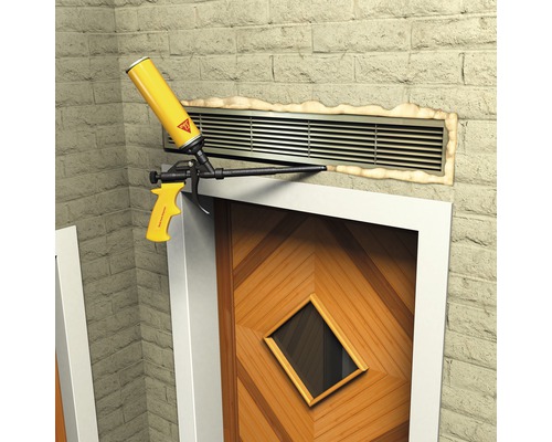 Pistolet à mousse scellant une grille de ventilation au-dessus d''une porte