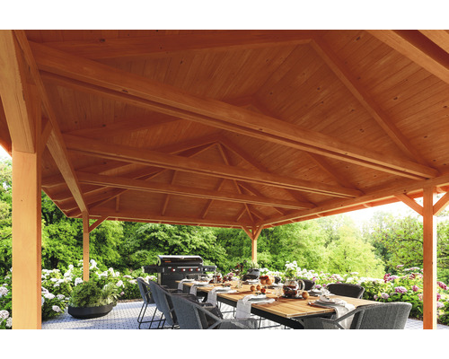 Vue détaillée d''un pavillon de jardin en bois avec table à manger et barbecue dans le jardin