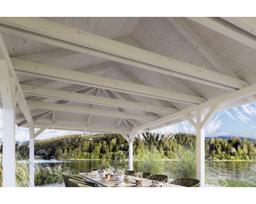 Pavillon en bois avec vue sur le lac et table dressée