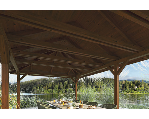 Pavillon en bois avec table dressée et vue sur le lac