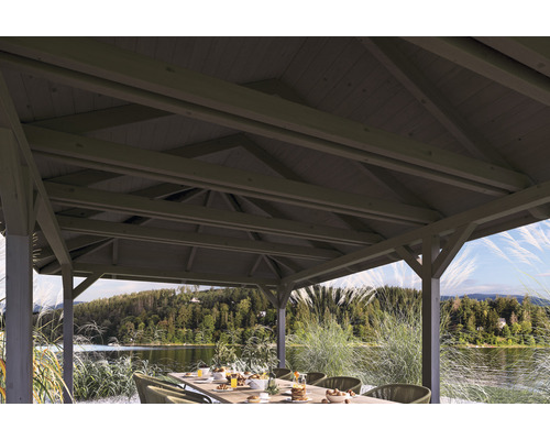 Holzpavillon mit Tisch und Stühlen am Seeufer