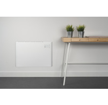 Szene mit einem weißen Wandkonvektor neben einem hellen Holztisch mit Pflanzen