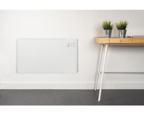 Radiateur plat blanc au mur, à côté d''un bureau avec deux plantes