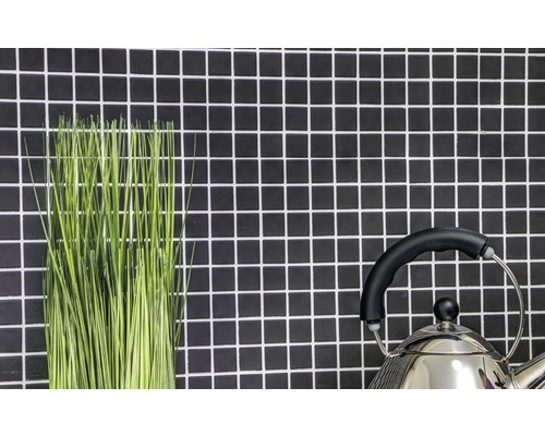 Halmes verts décoratifs et une bouilloire devant un mur avec des carreaux de mosaïque