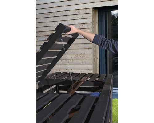 Offener Mülltonnenbox-Deckel mit Hand im Aussenbereich.