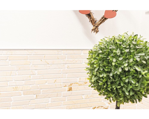 Wandfliesen in Steinoptik und künstlicher Buchsbaum in Kugelform als Dekoration