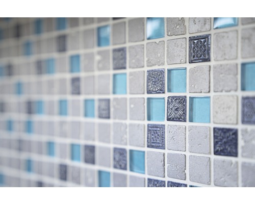 Nahaufnahme einer Wand mit quadratischen Mosaikfliesen in Steinoptik, Glas und mit Ornamenten