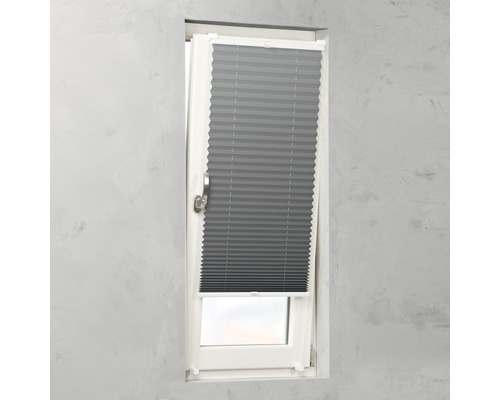 Store plissé gris sur une fenêtre pour le contrôle de la lumière.
