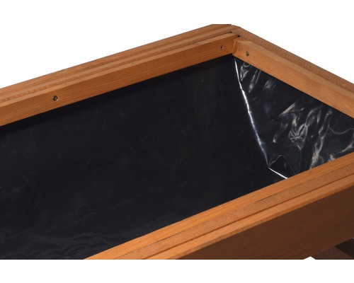 Vue détaillée d''un potager surélevé recouvert d''un film plastique.