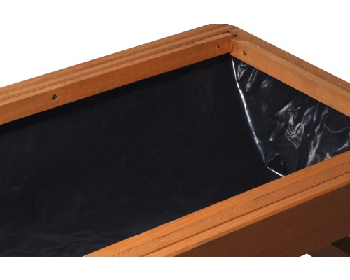 Detailansicht eines Hochbeets mit Holzrahmen und schwarzer Pflanzfolie.