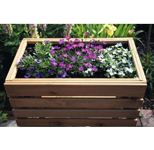 Jardinière en bois plantée de différentes fleurs dans le jardin