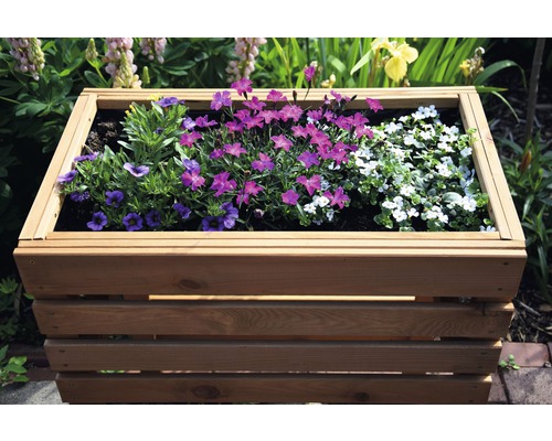 Jardinière en bois plantée de différentes fleurs dans le jardin