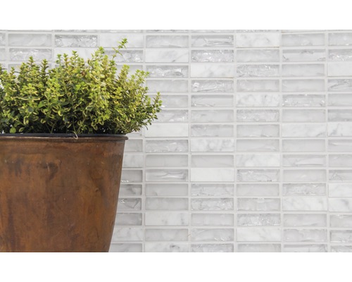 Mur décoratif avec carreaux de mosaïque de verre blancs et plante en pot