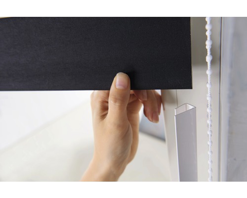 Nahaufnahme einer Person, die eine schwarze Jalousie mit Kettenzug bedient