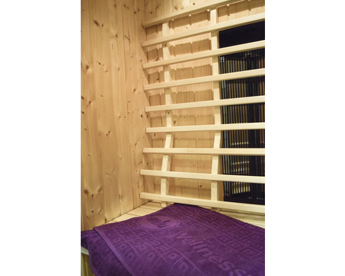 Innenausstattung einer Sauna mit Holzverkleidung, Infrarotstrahler und Handtuch